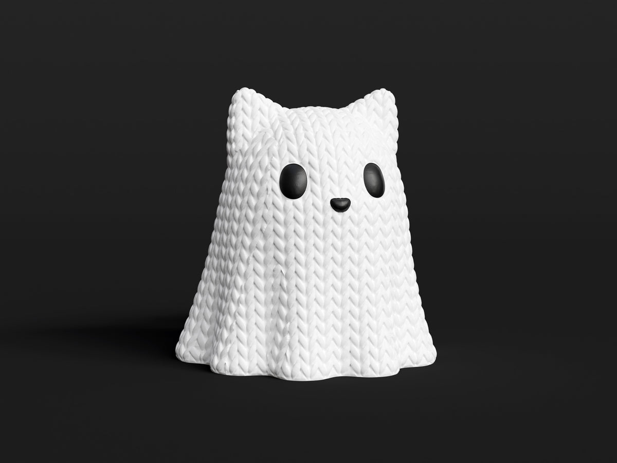 Gros plan d'un chat-fantôme tricoté blanc aux oreilles de chat et à la douce texture crochetée