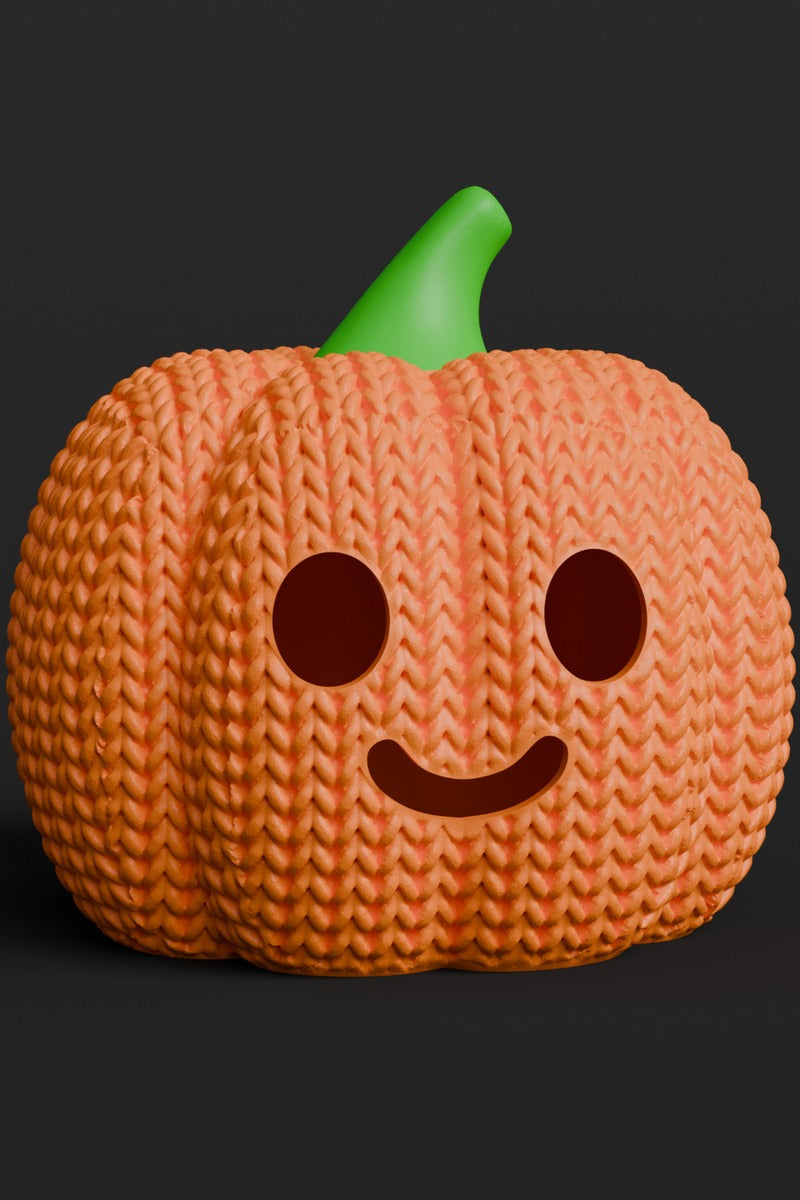 Gros plan d'une citrouille d'Halloween tricotée avec visage de citrouille et douce texture orange