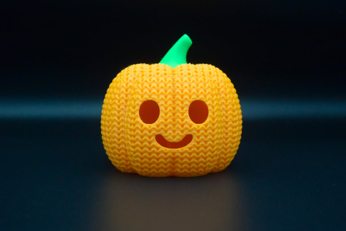 Détail de texture d'une citrouille d'Halloween façon tricot avec motif tissé et visage sculpté