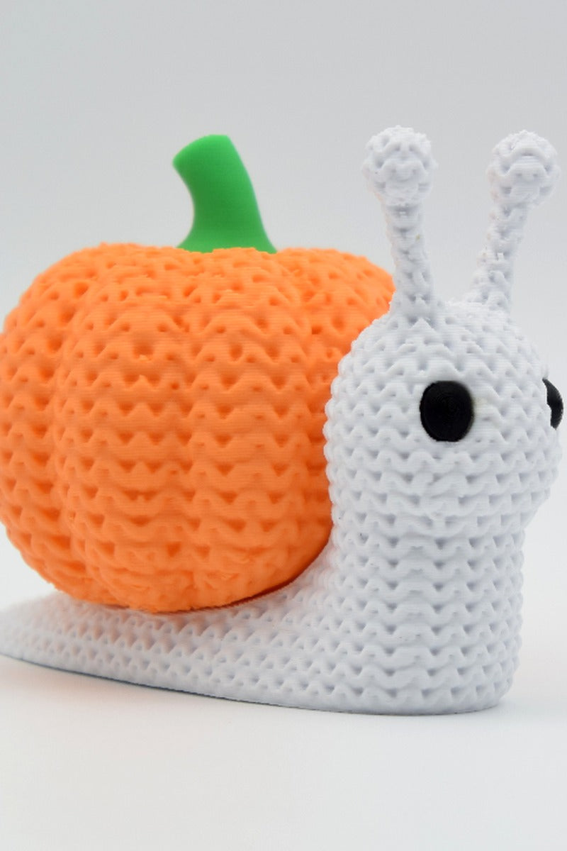 Gros plan d'un escargot-citrouille tricoté à la douce texture crochetée et à la coquille orange côtelée