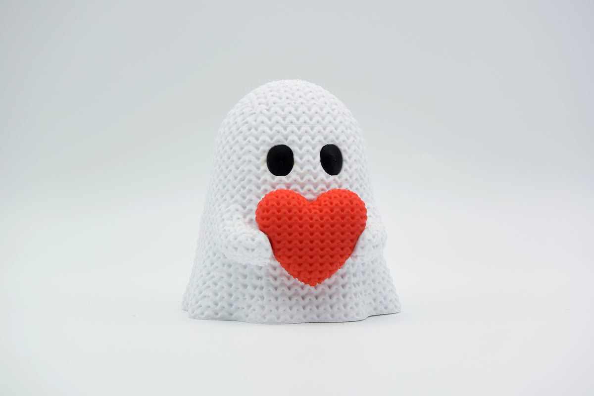 Gros plan d'un fantôme tricoté avec cœur, blanc et rouge, douce texture crochetée