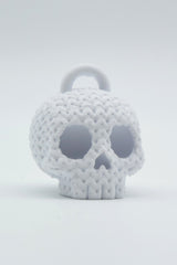 Gros plan d'un porte-clés tête de mort tricoté à texture crochetée sur fond clair