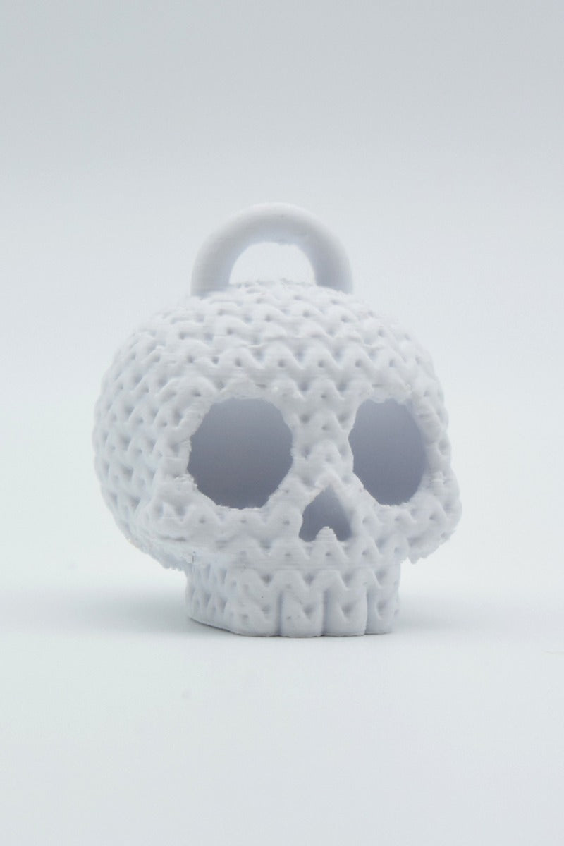 Gros plan d'un porte-clés tête de mort tricoté à texture crochetée sur fond clair