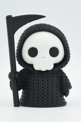 Gros plan d'une Faucheuse tricotée en cape à capuche avec sa faux, douce texture crochetée