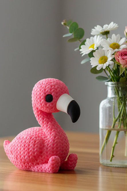 Gros plan d'une figurine de flamant rose tricoté, aspect crocheté, debout