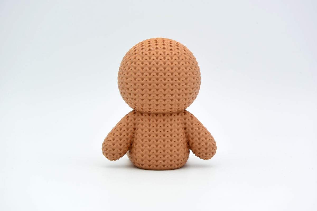 Détail de texture du bonhomme en pain d'épices façon tricot, surface crochetée douce et sourire en glaçage