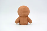 Détail de texture du bonhomme en pain d'épices façon tricot, surface crochetée douce et sourire en glaçage