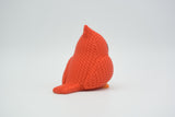 Petit cardinal rouge façon tricot sur une étagère en bois près de plantes séchées