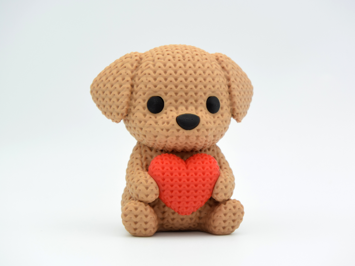 Gros plan d'une décoration chien crochetée avec un petit cœur et une douce texture de mailles