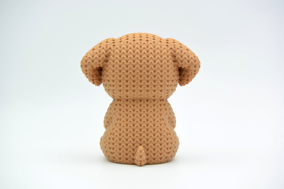 Gros plan d'une décoration chien crochetée avec un petit cœur et une douce texture de mailles