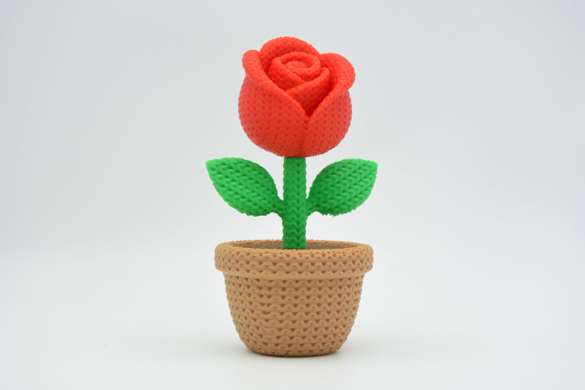 Rose tricotée sur une étagère en bois clair à côté d'une bougie dans un intérieur scandinave