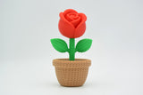 Rose tricotée sur une étagère en bois clair à côté d'une bougie dans un intérieur scandinave