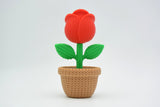 Gros plan d'une rose tricotée décorative aux pétales doux dans des tons rouges chaleureux