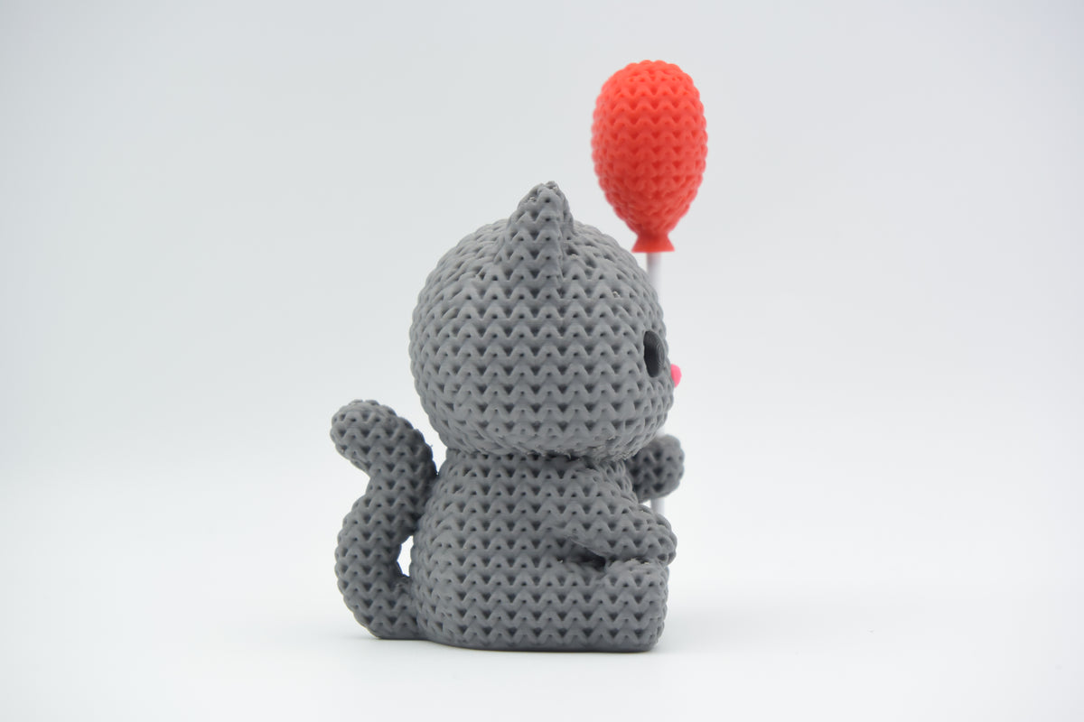 Chat tricoté avec ballon cœur sur une étagère en bois clair dans un salon scandinave