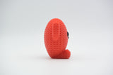 Gros plan d'une petite figurine de cœur rouge tricoté à texture crochetée et visage simple