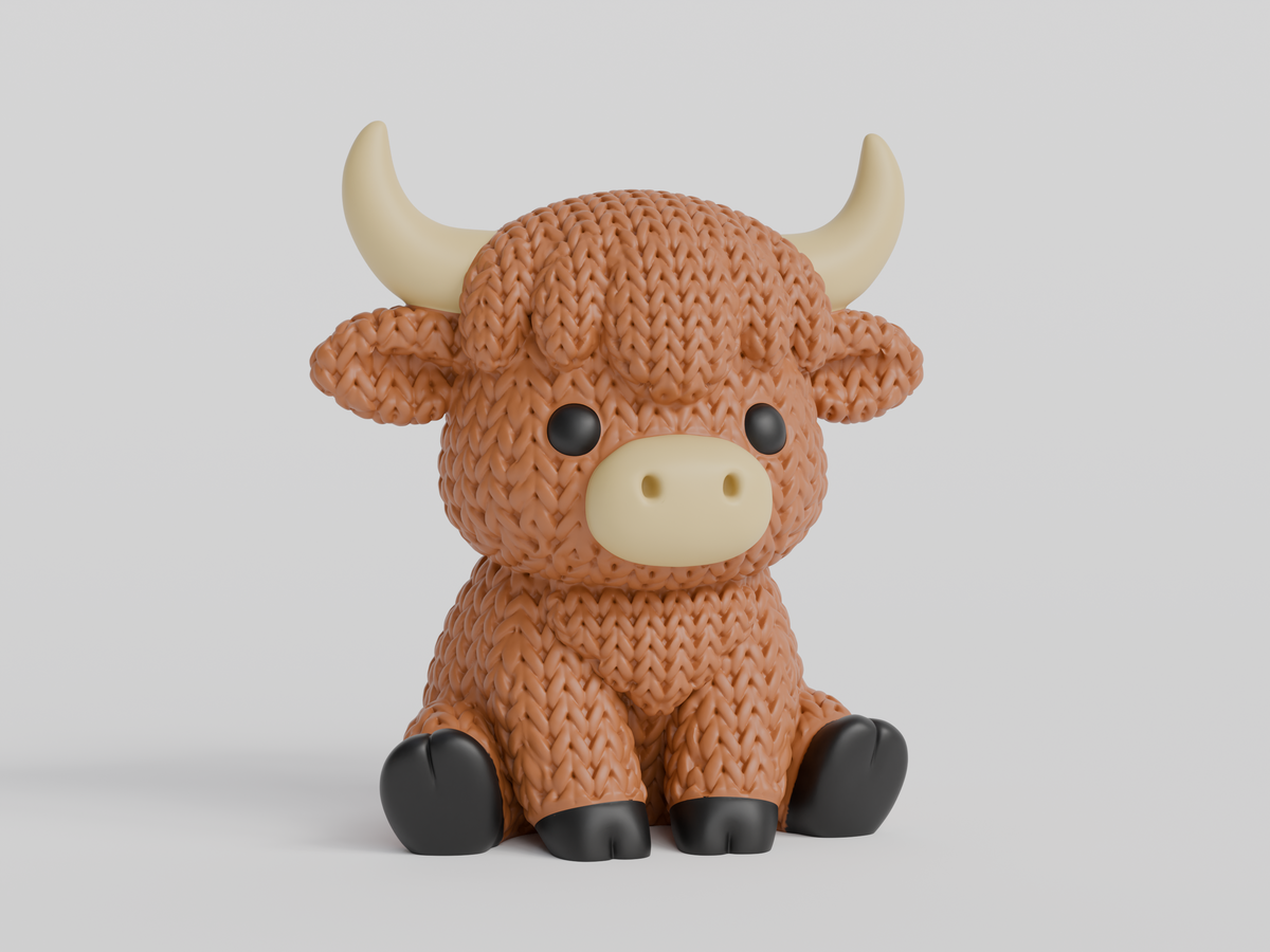 Gros plan d'une vache Highland tricotée au pelage crocheté et aux petites cornes sculptées