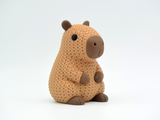 Gros plan d'une figurine de capybara tricoté dans des tons bruns chauds, texture crochetée