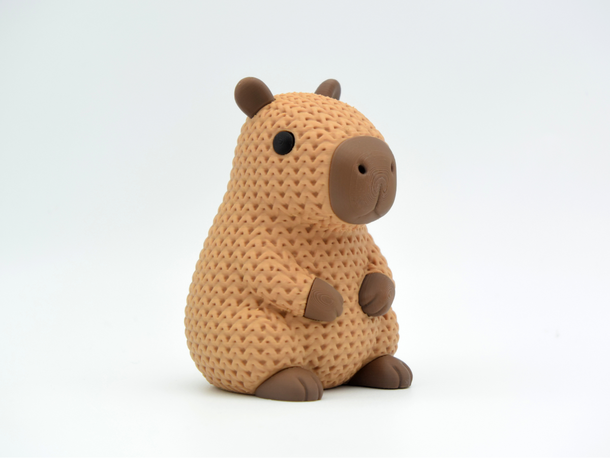 Gros plan d'une figurine de capybara tricoté dans des tons bruns chauds, texture crochetée