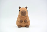 Gros plan d'une figurine de capybara tricoté dans des tons bruns chauds, texture crochetée