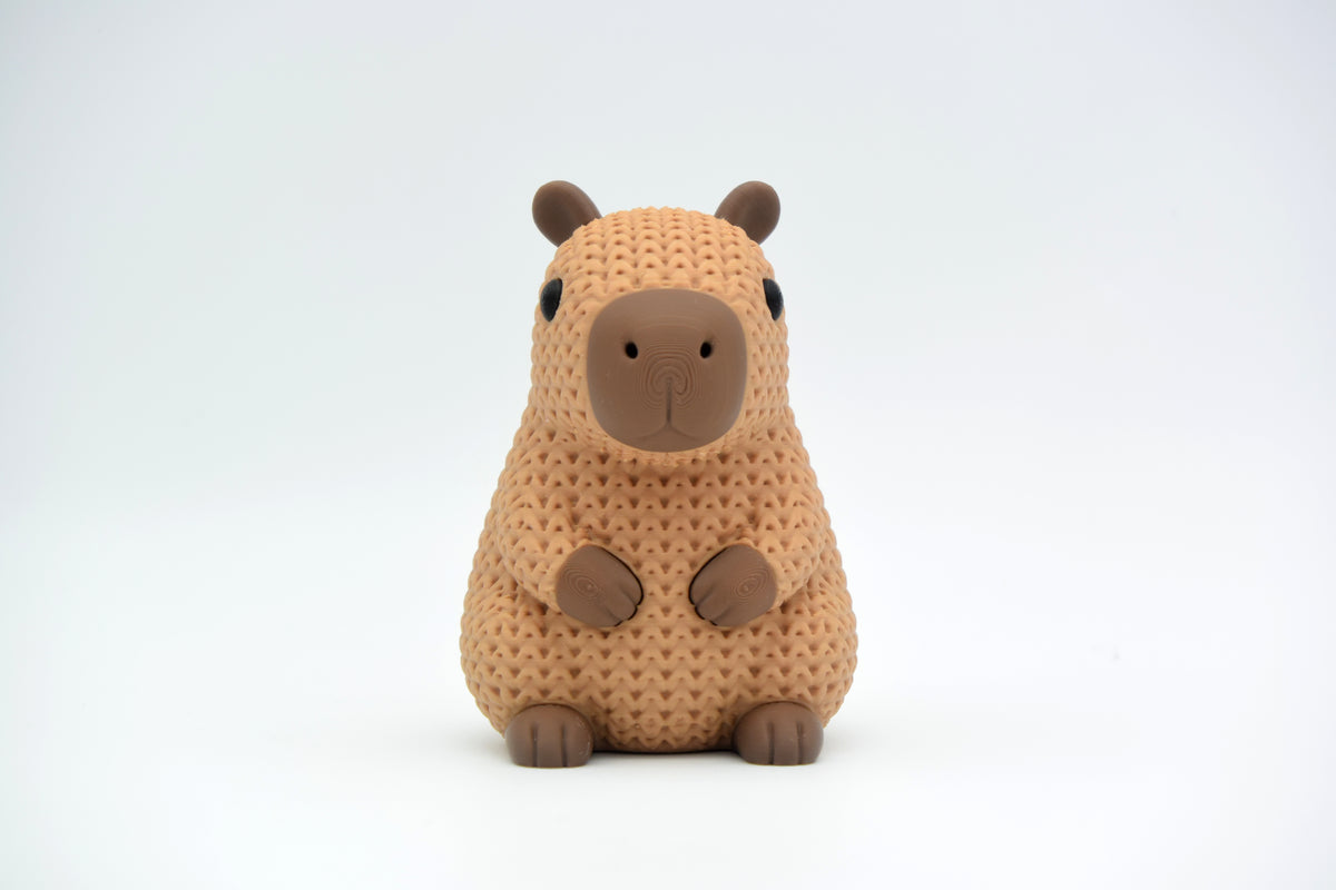 Gros plan d'une figurine de capybara tricoté dans des tons bruns chauds, texture crochetée