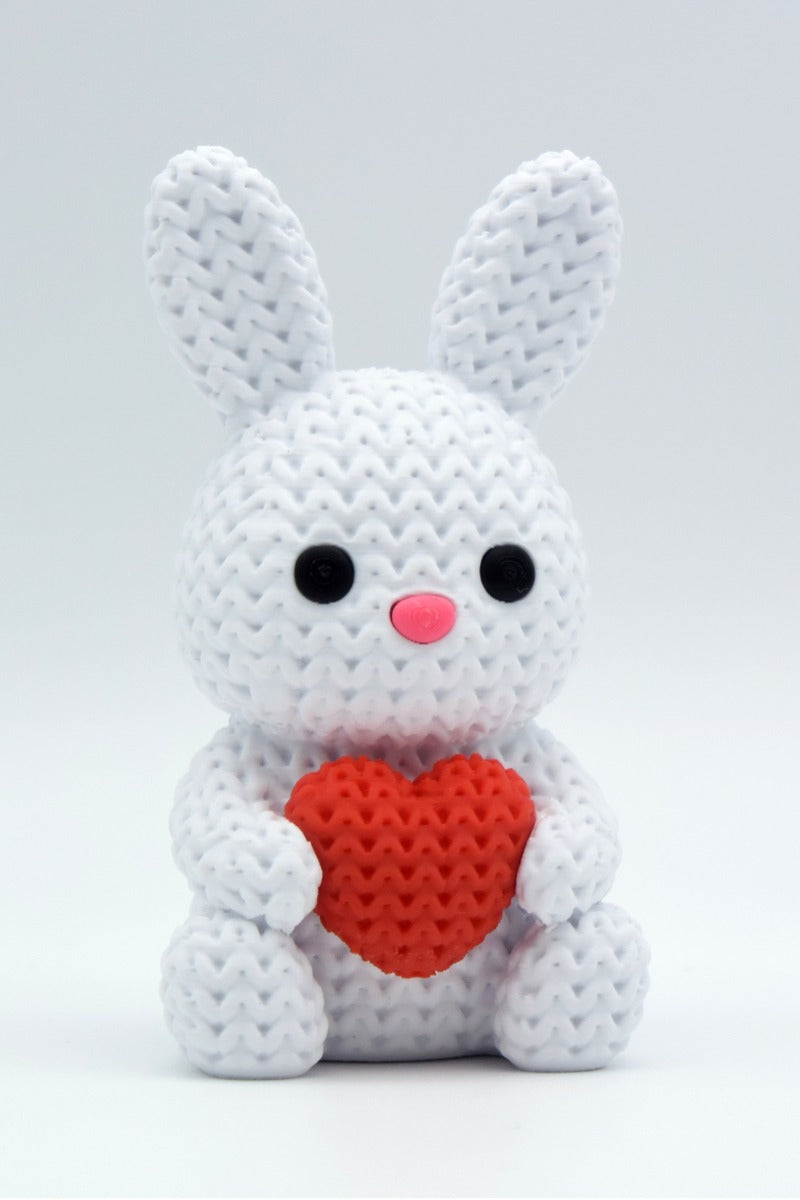 Gros plan d'un lapin tricoté blanc avec cœur et surface texturée