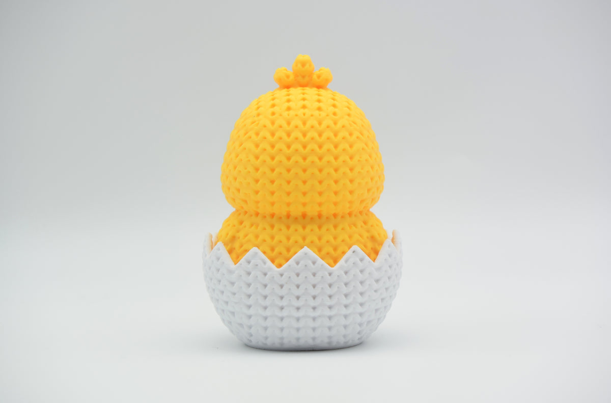 Détail de texture d'un poussin de Pâques façon tricot qui éclot, au motif de mailles tissé