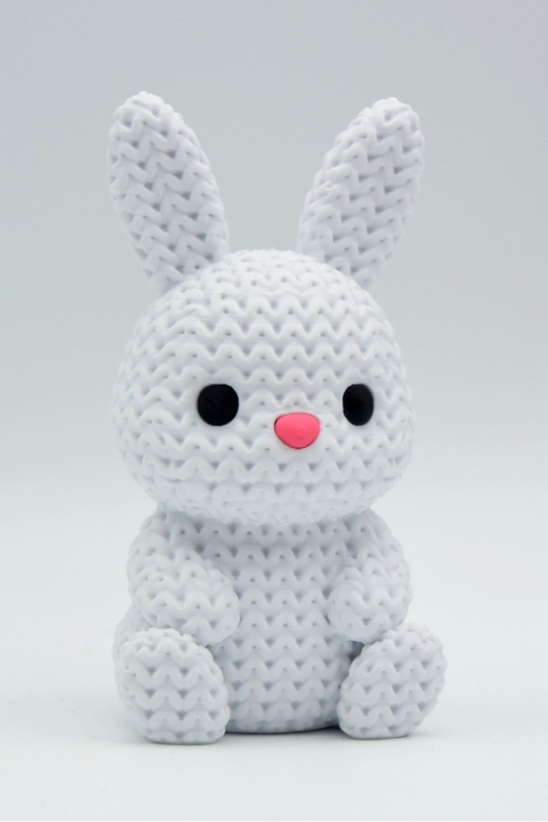 Gros plan d'un petit lapin tricoté à la douce texture crochetée sur fond blanc