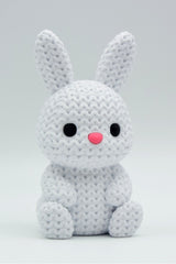 Gros plan d'un petit lapin tricoté à la douce texture crochetée sur fond blanc
