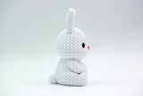 Gros plan d'un petit lapin tricoté à la douce texture crochetée sur fond blanc