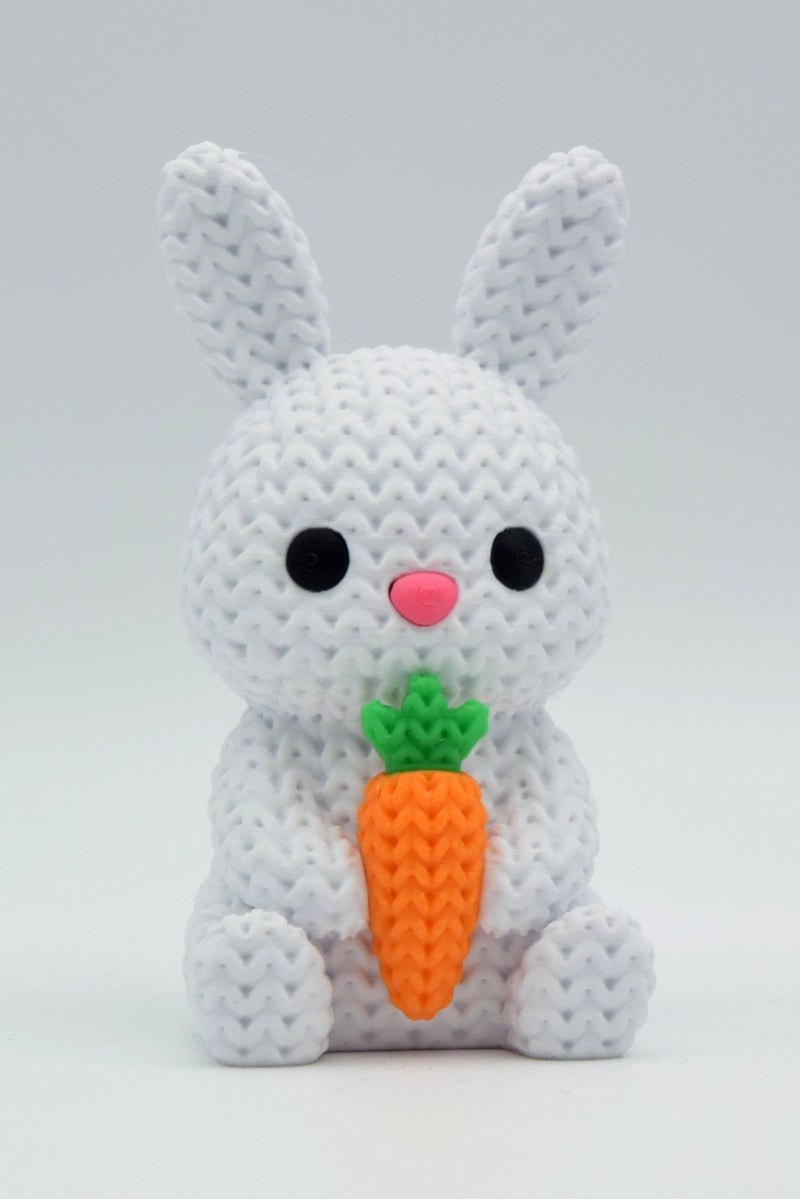 Gros plan d'un lapin tricoté avec carotte dans des tons crème
