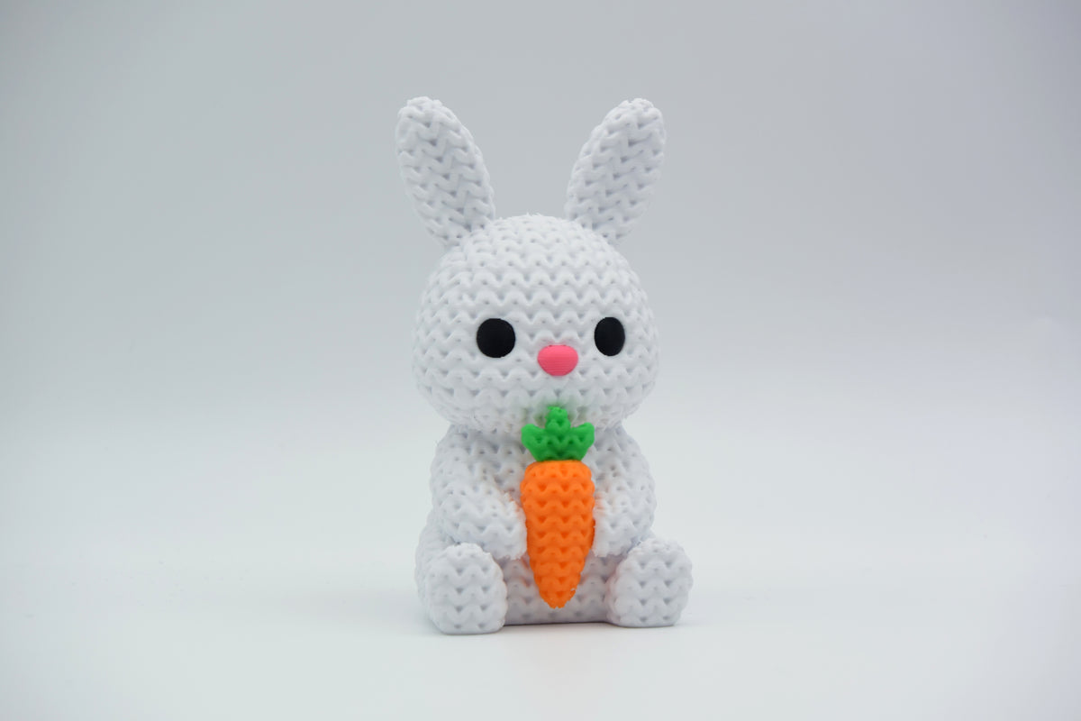 Lapin tricoté avec carotte sur une étagère en bois avec verdure de Pâques