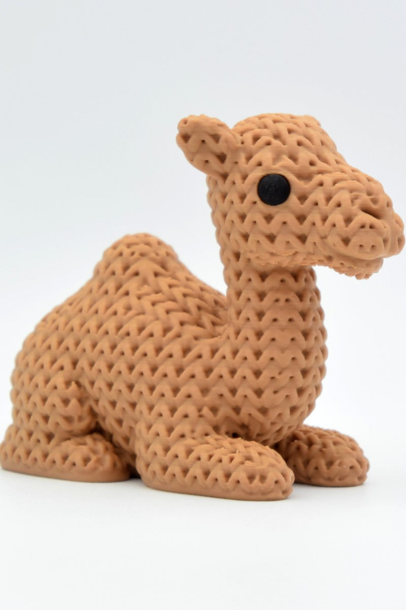 Gros plan d'une figurine de chameau tricoté à la douce texture tissée sur fond blanc