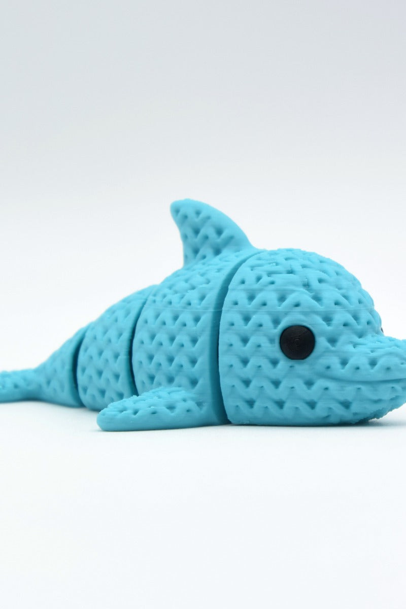 Gros plan d'une figurine de dauphin tricoté articulé gris clair, texture crochetée