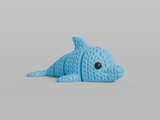 Gros plan d'une figurine de dauphin tricoté articulé gris clair, texture crochetée