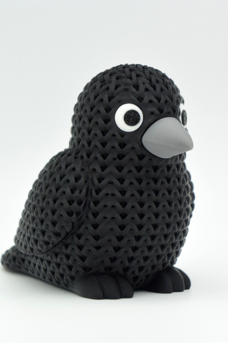 Gros plan d'une figurine de corneille tricotée, aspect crocheté et yeux clipsés détaillés