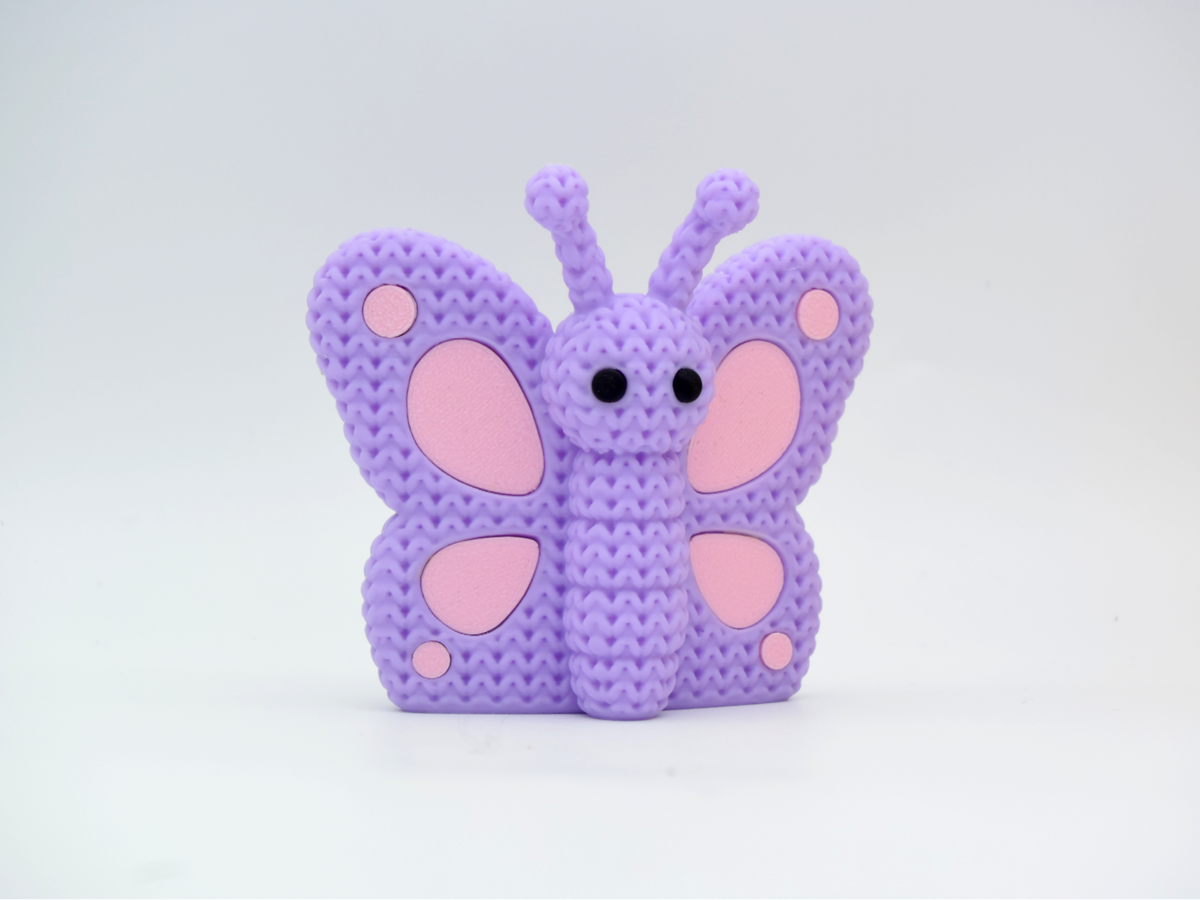 Gros plan d'un papillon tricoté aux ailes crochetées dans des couleurs chaudes