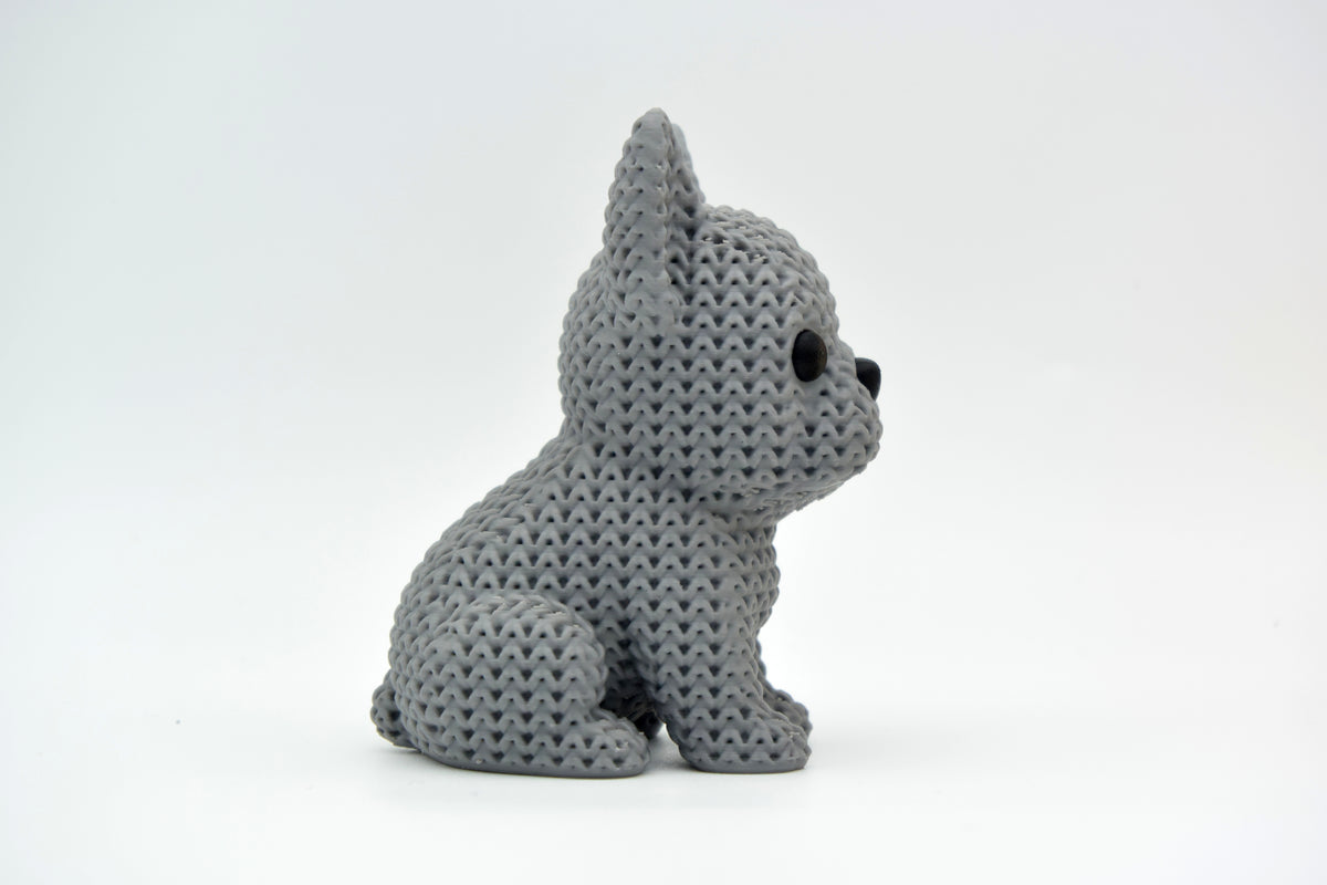 Figurine de bouledogue français tricoté sur une étagère en bois près d'une petite plante
