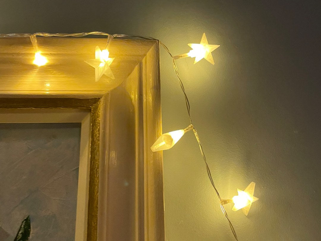 Caches en forme d'étoile posés sur une guirlande lumineuse