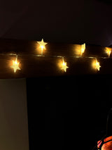 Caches en forme d'étoile posés sur une guirlande lumineuse