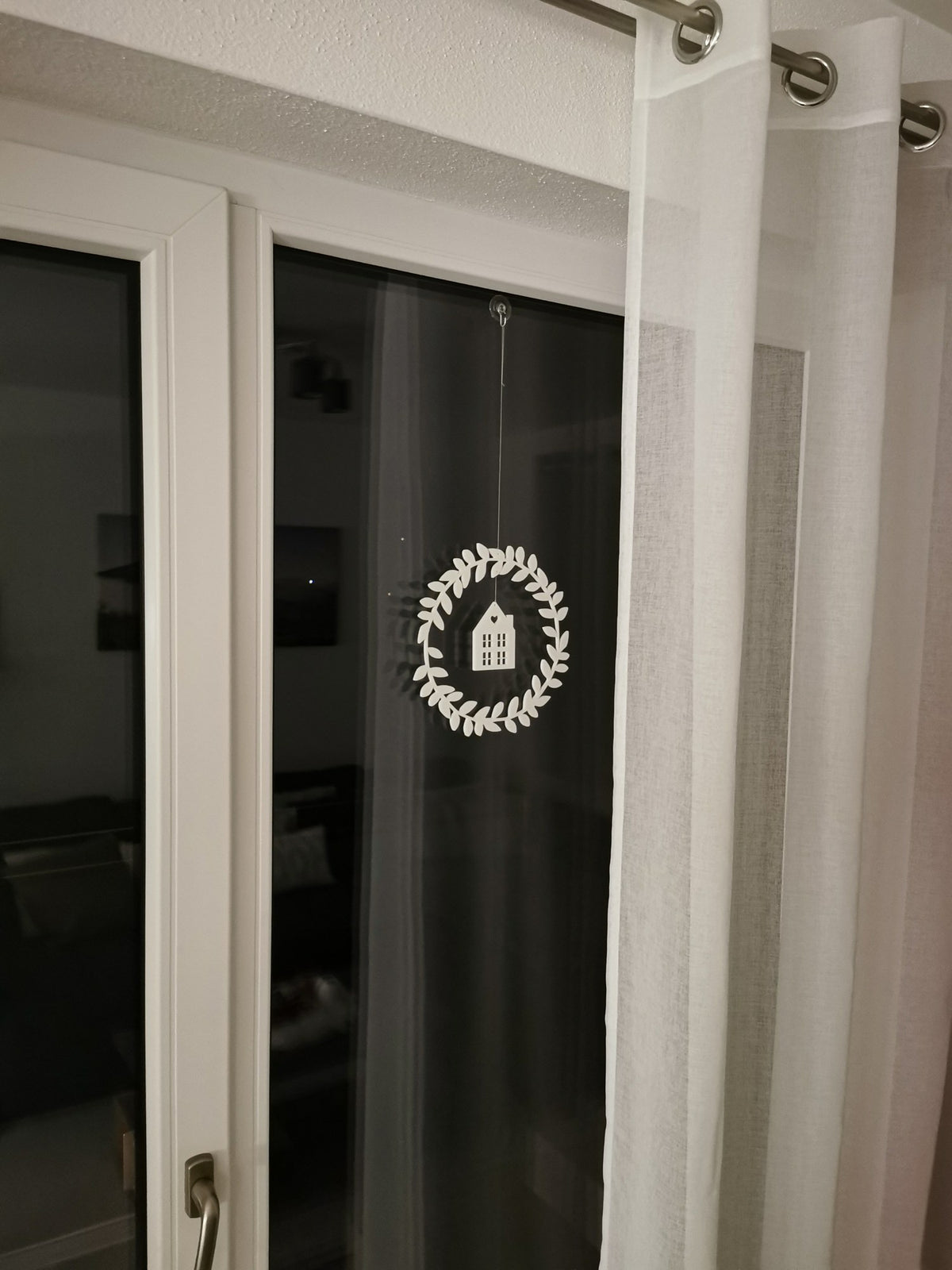 Couronne de fenêtre avec maison et cœur suspendus